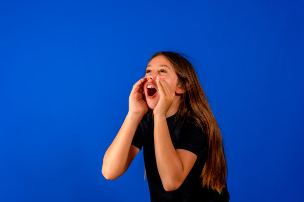 滑稽的孩子的肖像，触摸手，脸颊，脸，尖叫，盯着，omg，难以置信的孤立在蓝色背景上图片下载