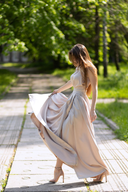 快乐的女孩穿着长裙在街上摆造型。图片下载
