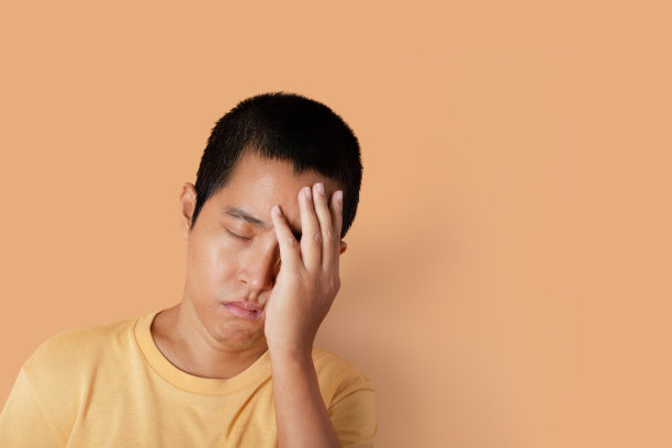 年轻人的肖像穿着t恤感觉无聊的橙色背景与复制空间。图片下载