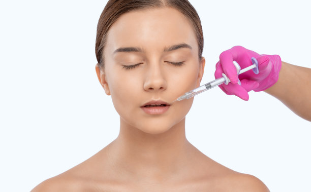 美容师为一个美丽的女人做嘴唇增强和抗皱纹注射。美容院的女性美容。图片下载