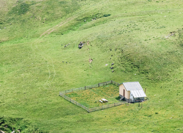 在罗马尼亚的布基山脉，鸟瞰图中被新鲜的绿色牧场包围的空羊圈图片下载