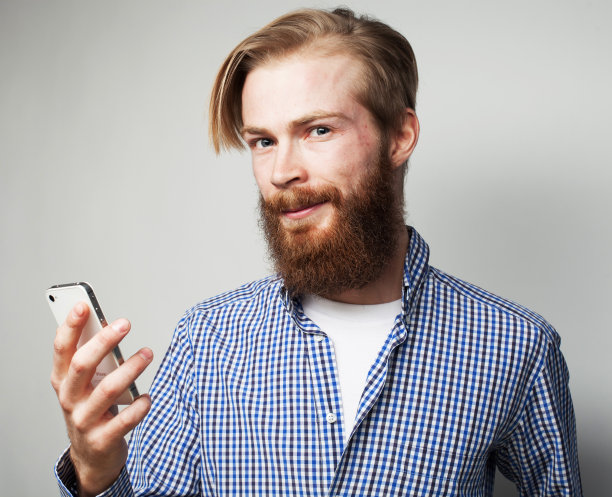 生活方式、情感、科技和人的观念。快乐的大胡子年轻人使用移动互联网图片下载