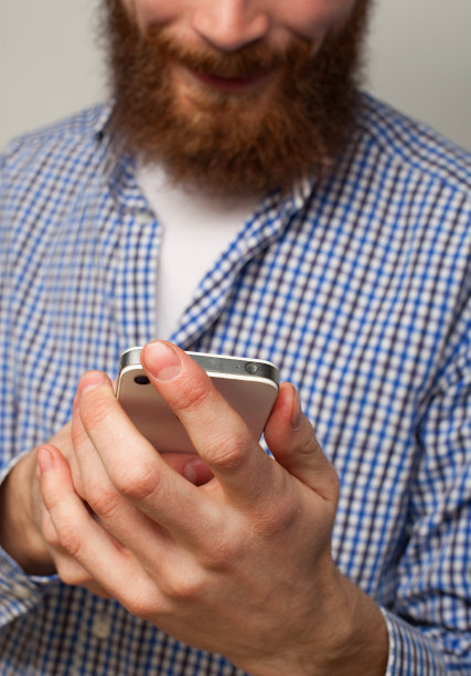 生活方式、情感、科技和人的观念。快乐的大胡子年轻人使用移动互联网图片下载