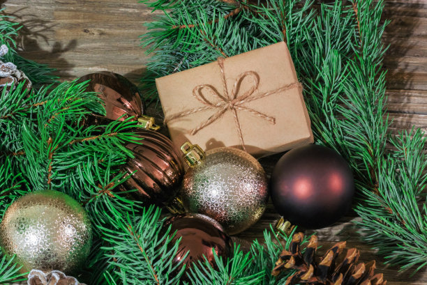 特写照片云杉树枝，圣诞玩具，松果和礼盒上的木制背景图片下载