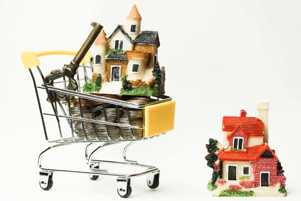 购物车载着硬币，房子和关键概念的想法。复制空间，买卖房地产概念。图片下载