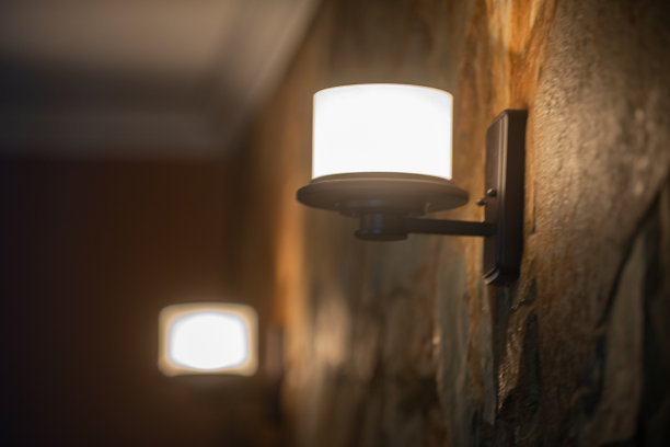 昏暗的黑色烛台安装在棕色的石墙上图片下载