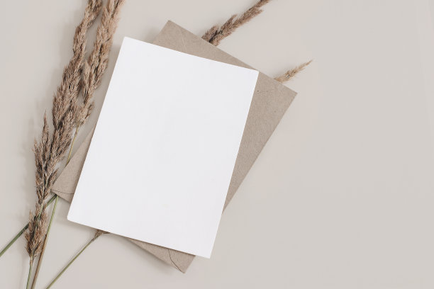 秋天结婚，生日作文文具。空白的贺卡，棕色信封的邀请函模型。干草，羊茅植物在米色桌子背景。秋平卧，俯视图。Copyspace图片下载