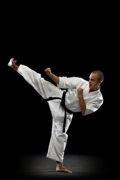 全长垂直肖像的年轻运动员练习空手道孤立在黑色的背景图片下载