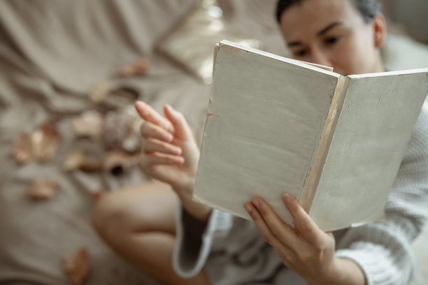 女人看书，书在女人手中特写。图片下载