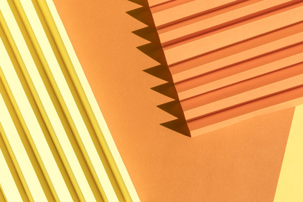 抽象橘色和黄色的纸张质感。折叠的纸有强烈的阳光阴影，几何形状和线条。极简主义的背景。图片下载