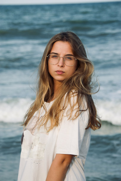 一个安详的女人，靠着大海站着图片下载