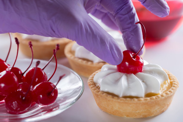 糕点师用樱桃装饰蛋糕。图片下载