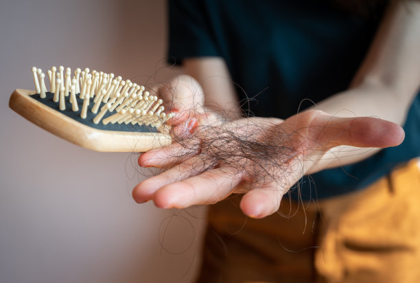 特写镜头:一名女子在梳理完头发后，手拿梳子，披头散发。图片下载
