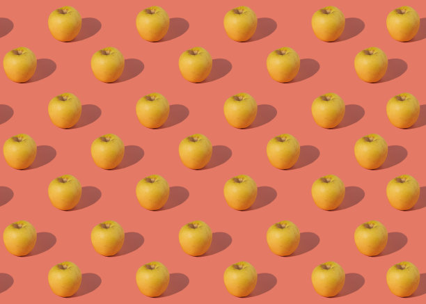 在粉红色背景上多汁的黄色苹果的图案图片下载