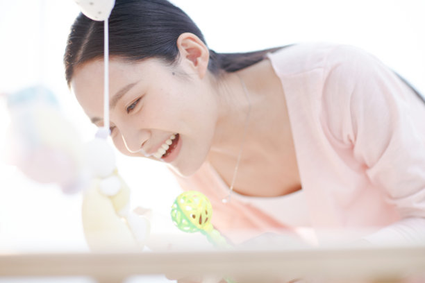 年轻妈妈在婴儿床旁图片下载