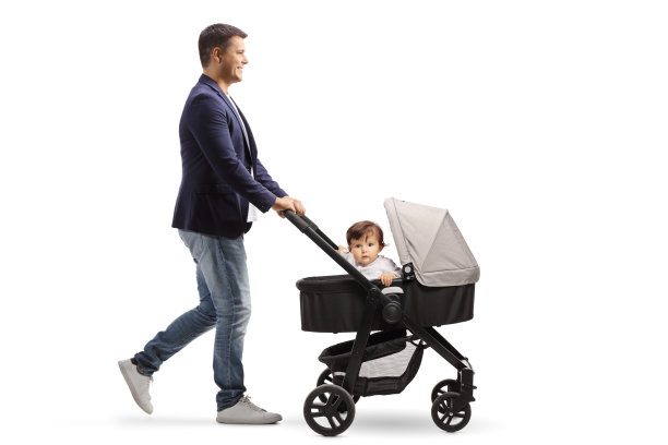 一个快乐的父亲推着婴儿车，一个婴儿偷看的全身侧面照片图片下载