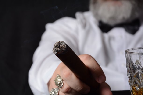 穿白衬衫手持古巴雪茄的优雅男人图片下载