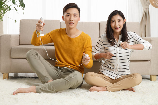 青年情侣坐着沙发上玩游戏图片下载