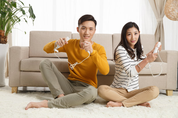 青年情侣坐着沙发上玩游戏图片下载