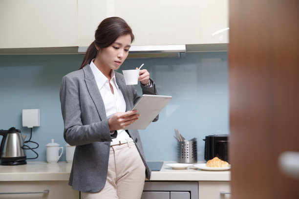 青年女人在厨房使用平板电脑图片下载