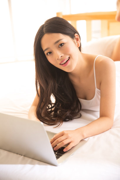 青年女人在卧室使用电脑图片下载