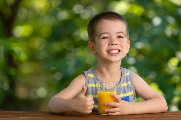 小男孩拿着果汁，竖起大拇指图片下载