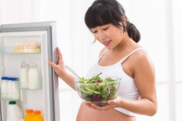 孕妇打开冰箱拿蔬菜图片下载