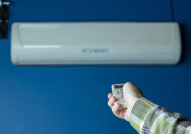 空调遥控器控制。蓝色墙上的空调图片下载