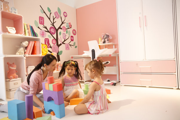 青年女人和两个女孩在卧室玩耍图片下载