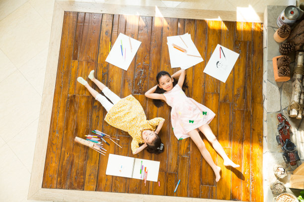 姐妹俩躺在地板上玩耍图片下载