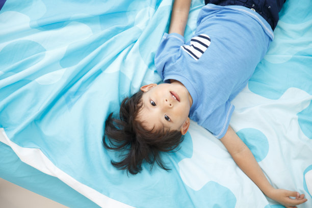 可爱的小男孩在床上玩耍图片下载