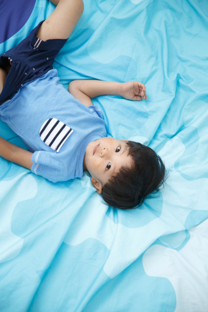 可爱的小男孩在床上玩耍图片下载