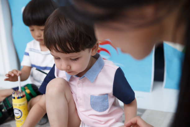 可爱的小男孩和指导教师在游戏室玩耍图片下载