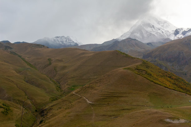 周围的山脉和白雪覆盖的山峰图片下载
