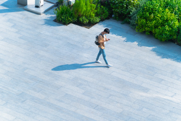空中俯视图，戴着口罩的人走过地面黑色剪影的步行街，社会新常态生活概念，预防新冠疫情和空气污染。图片下载