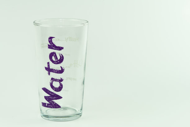 白色背景上有水字的空玻璃杯图片下载