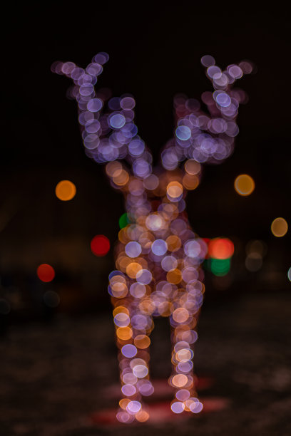 节日花环灯饰在鹿形状无焦点抽象城市装饰概念垂直照片图片下载
