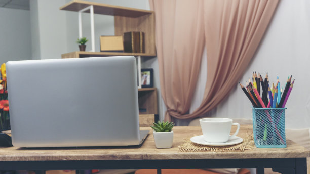 学生概念桌。桌上型笔记本电脑为学习考试，电脑，耳机，铅笔，仙人掌，和一杯咖啡放在学校的桌子上，供学生在家里在线工作。图片下载