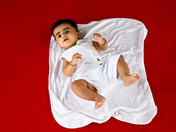 可爱的印度男孩穿着白色的洗礼服图片下载