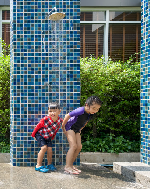 亚洲小孩在游泳池玩完后洗掉屁股和身体上的盐水。图片下载