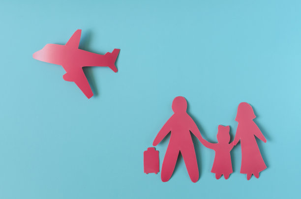 概念红色人物形象的家庭与一个手提箱和飞行的飞机在一个浅色的背景。成人和儿童的纸板人物，家庭度假的概念图片下载