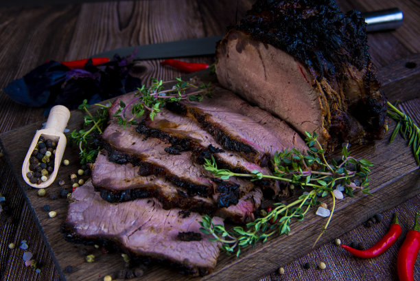 在砧板上烤牛肉。木制背景。图片下载
