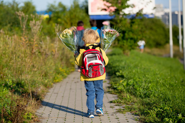 快乐的孩子，早上去上学，第一天，为老师送上一束关怀的鲜花图片下载