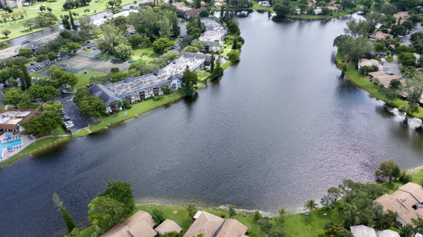 在佛罗里达劳德代尔堡一个阳光明媚的日子里，从上往下拍摄的照片正对着一条穿过一片水域的空马路。图片下载