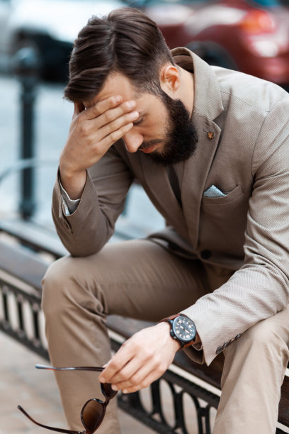 街上的那个大胡子男人病了。企业家因为工作而头痛。商人坐在长凳上休息图片下载
