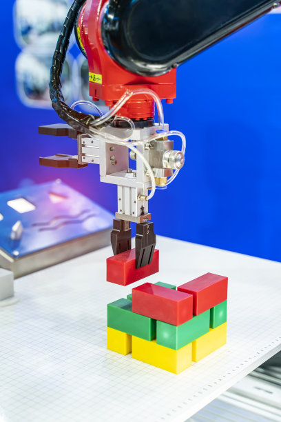 机械手夹臂拾取和放置玩具块，制造业，工业，工程，人工智能，自动化技术概念图片下载