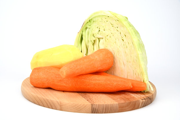 切菜板上的卷心菜、去皮的胡萝卜和土豆。图片下载