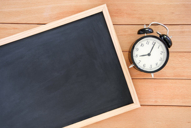 空白的黑板和桌子上的闹钟。回到学校的概念。图片下载