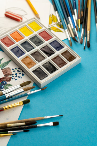 水彩颜料和画笔。艺术家的工作场所和办公桌。调色板。蓝色背景。放置你的文本。艺术创造。本空间图片下载
