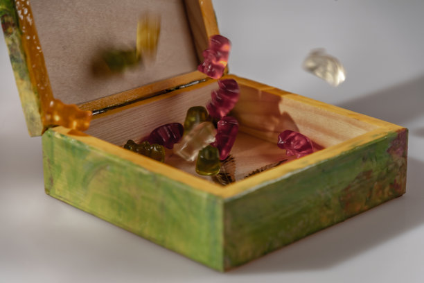 彩色木盒与白色背景上的帽子与反射和彩色糖果图片下载